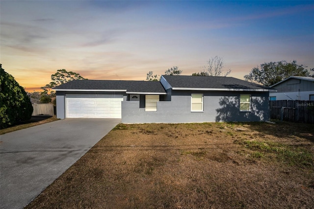 single story home with a garage and a lawn