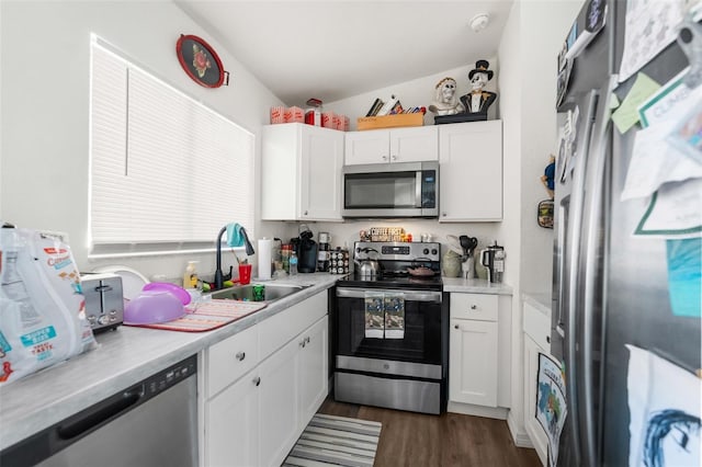 kitchen featuring vaulted ceiling, dark hardwood / wood-style floors, white cabinetry, sink, and stainless steel appliances