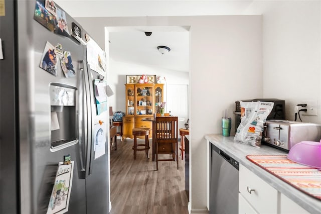 kitchen featuring white cabinetry, stainless steel appliances, and hardwood / wood-style floors