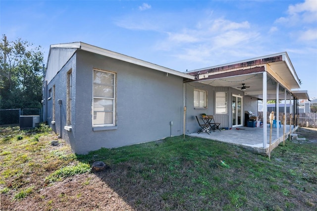 back of property with cooling unit, a yard, a patio area, and ceiling fan