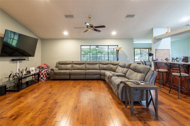 living room featuring lofted ceiling, hardwood / wood-style floors, and ceiling fan