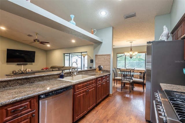 kitchen with lofted ceiling, sink, light hardwood / wood-style flooring, plenty of natural light, and stainless steel appliances