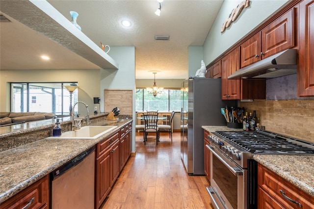 kitchen with sink, tasteful backsplash, plenty of natural light, stainless steel appliances, and light hardwood / wood-style floors