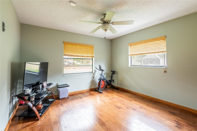 misc room featuring ceiling fan, light hardwood / wood-style flooring, and a textured ceiling