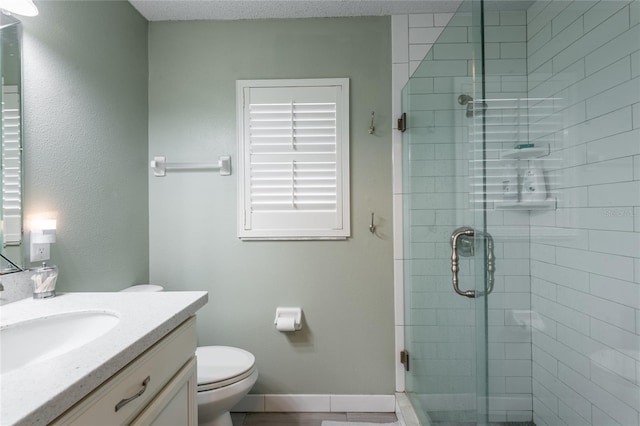 bathroom with vanity, a shower with door, and toilet