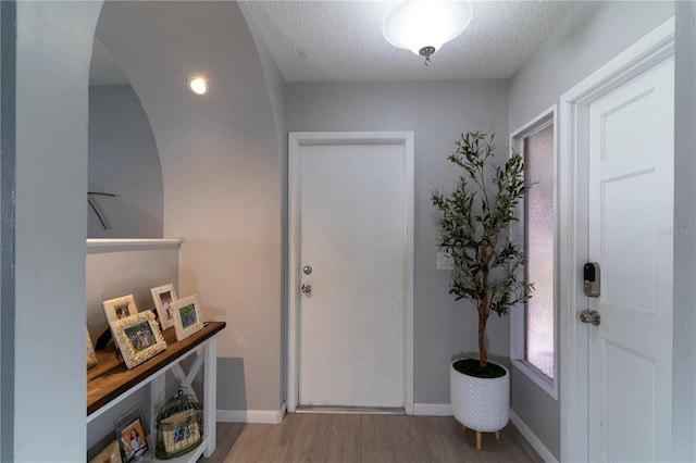 entrance foyer with hardwood / wood-style floors and a textured ceiling