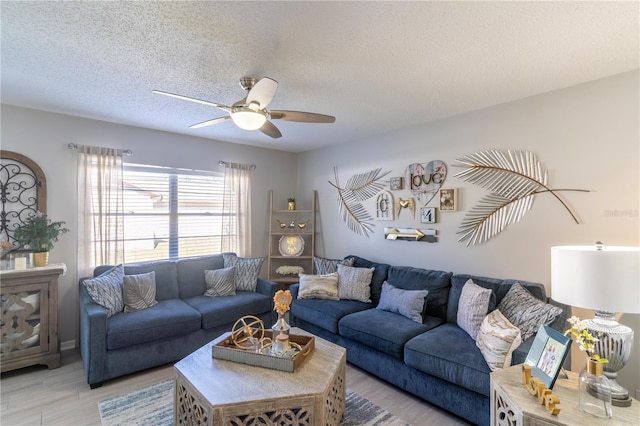 living room with a textured ceiling, ceiling fan, and light hardwood / wood-style floors