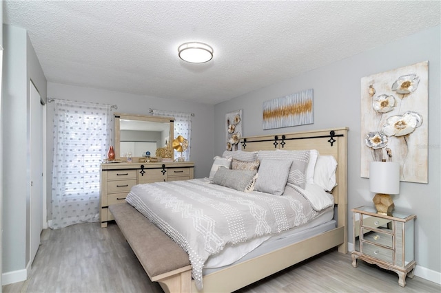 bedroom with light hardwood / wood-style flooring and a textured ceiling