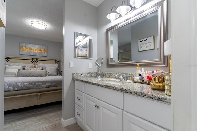 bathroom featuring hardwood / wood-style flooring, vanity, and a textured ceiling