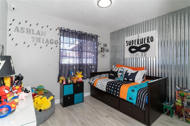 bedroom with hardwood / wood-style flooring and a textured ceiling