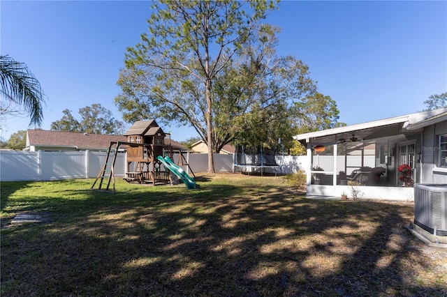 view of yard with a playground, central AC unit, a sunroom, and a trampoline