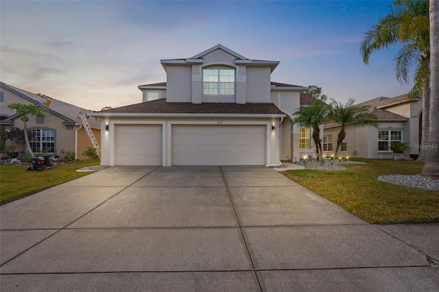 view of front of home with a yard and a garage