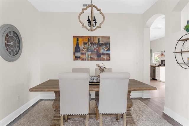 dining room featuring dark hardwood / wood-style flooring and a notable chandelier