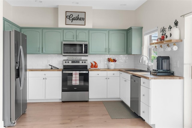 kitchen featuring sink, decorative backsplash, white cabinets, and appliances with stainless steel finishes