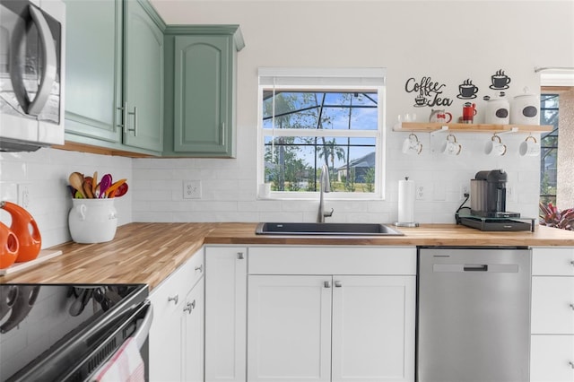 kitchen featuring range with electric stovetop, sink, butcher block counters, and stainless steel dishwasher