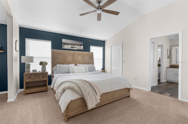 bedroom with connected bathroom, vaulted ceiling, a closet, ceiling fan, and carpet