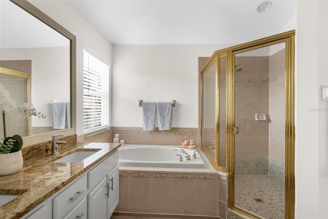 bathroom with vanity and shower with separate bathtub