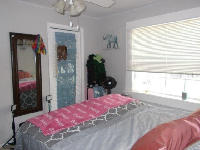 bedroom featuring ceiling fan and ornamental molding