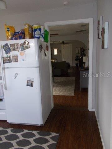 kitchen with dark hardwood / wood-style flooring and white fridge