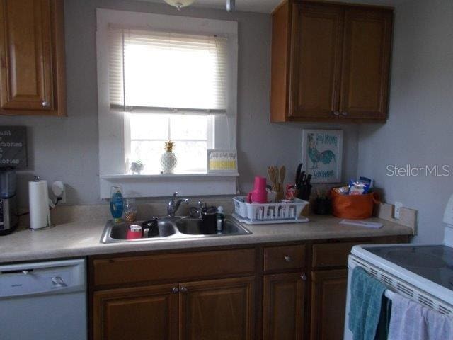 kitchen featuring white appliances and sink