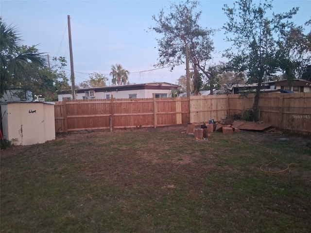 yard at dusk featuring a storage unit