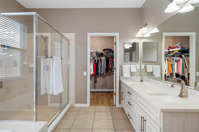 bathroom with tile patterned flooring, vanity, and walk in shower