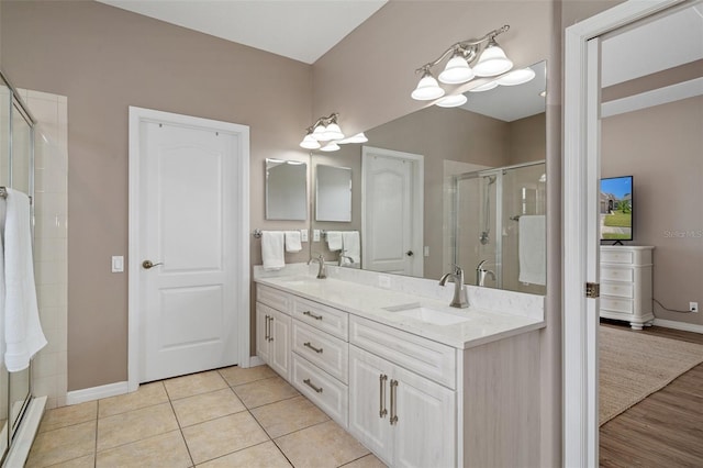 bathroom featuring vanity, tile patterned flooring, a shower with shower door, and baseboard heating