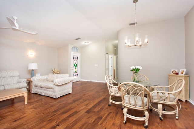 dining area featuring vaulted ceiling, ceiling fan with notable chandelier, and dark hardwood / wood-style flooring