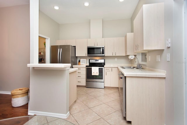 kitchen with light tile patterned flooring, tile countertops, sink, kitchen peninsula, and stainless steel appliances