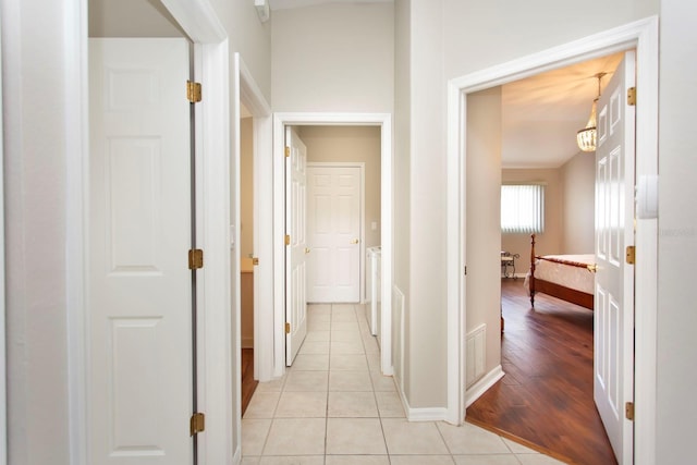 hall with independent washer and dryer and light tile patterned floors