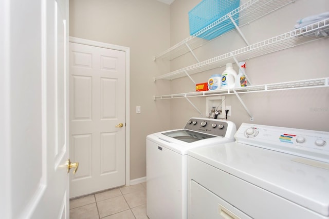 washroom featuring washing machine and dryer and light tile patterned flooring