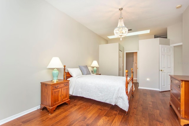 bedroom featuring an inviting chandelier and dark hardwood / wood-style flooring