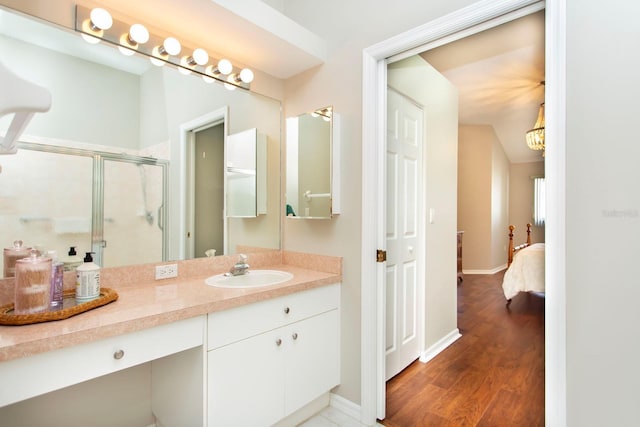 bathroom featuring vanity, hardwood / wood-style flooring, and a shower with shower door