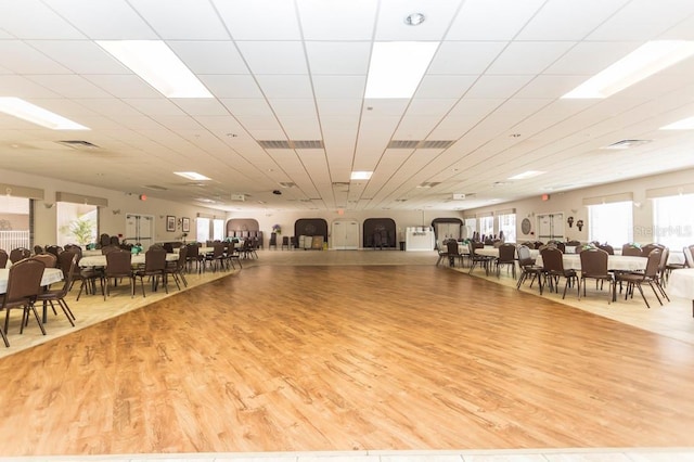 gym featuring a drop ceiling and light wood-type flooring