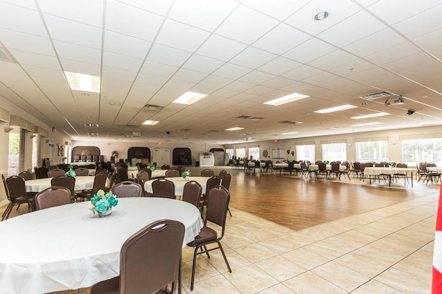 tiled dining space with a paneled ceiling