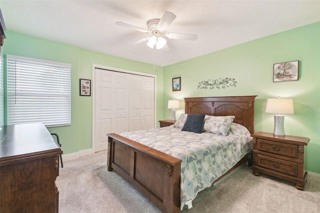 bedroom featuring light carpet, ceiling fan, and a closet