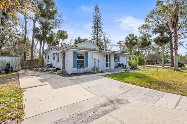 view of front of property with ac unit and a front lawn