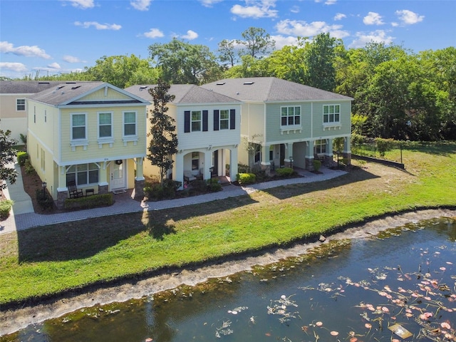 view of front facade featuring a front lawn and a water view