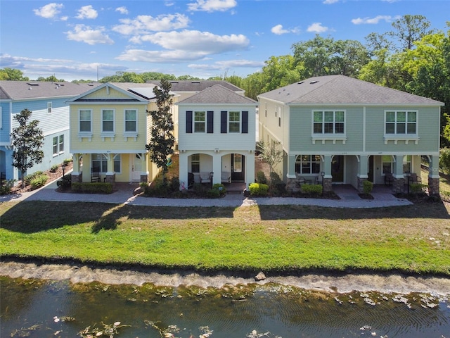 view of front of property featuring a water view, covered porch, and a front yard