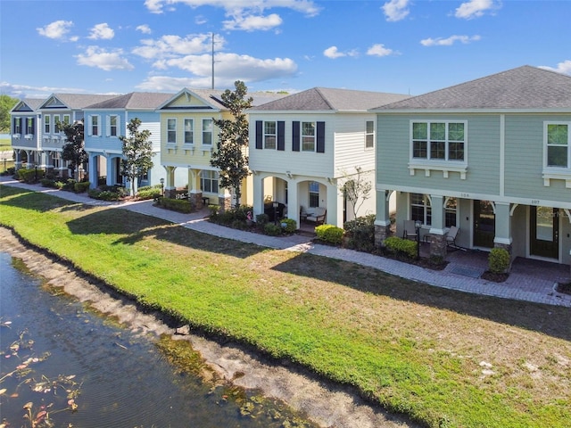 multi unit property featuring a front yard and a water view