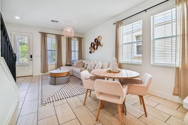 dining room with ornamental molding, a healthy amount of sunlight, and light tile patterned floors