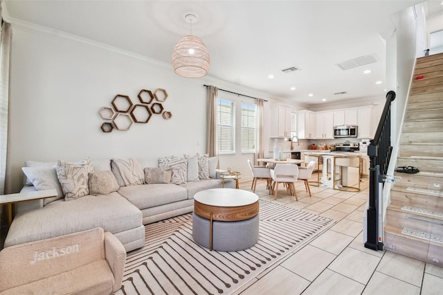 tiled living room with crown molding and sink