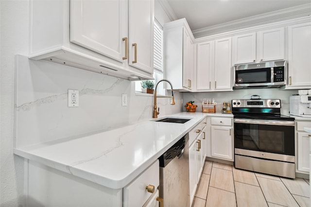 kitchen featuring sink, stainless steel appliances, ornamental molding, light stone countertops, and white cabinets