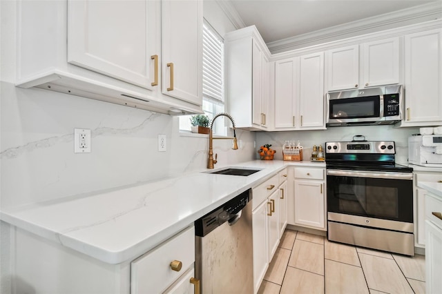 kitchen featuring stainless steel appliances, white cabinetry, sink, and light tile patterned flooring