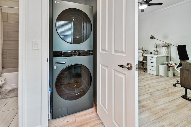 washroom with crown molding, stacked washer / drying machine, ceiling fan, and light hardwood / wood-style floors