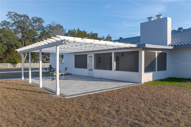 back of house with a sunroom, a pergola, a lawn, and a patio area