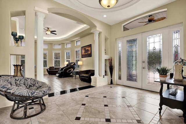 entrance foyer with plenty of natural light, a raised ceiling, and ornate columns