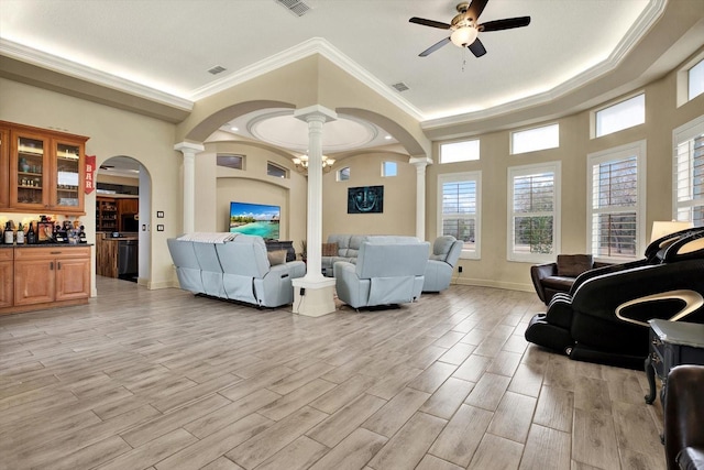 living room featuring crown molding, light wood-type flooring, and ornate columns