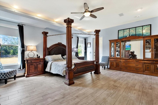 bedroom featuring ceiling fan, light hardwood / wood-style floors, and ornate columns