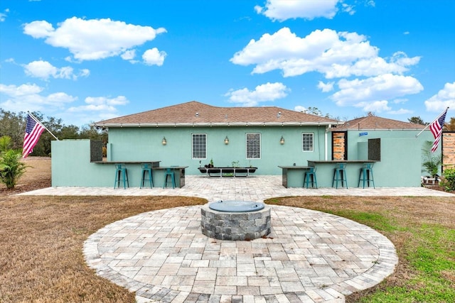 rear view of house with a bar, an outdoor fire pit, a patio area, and a lawn